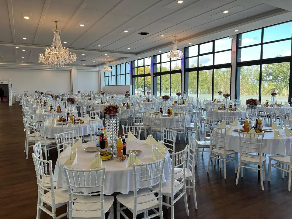 Großer Saal des Kristall Eventsaals, festlich eingedeckt mit Kronleuchtern und Glasfront